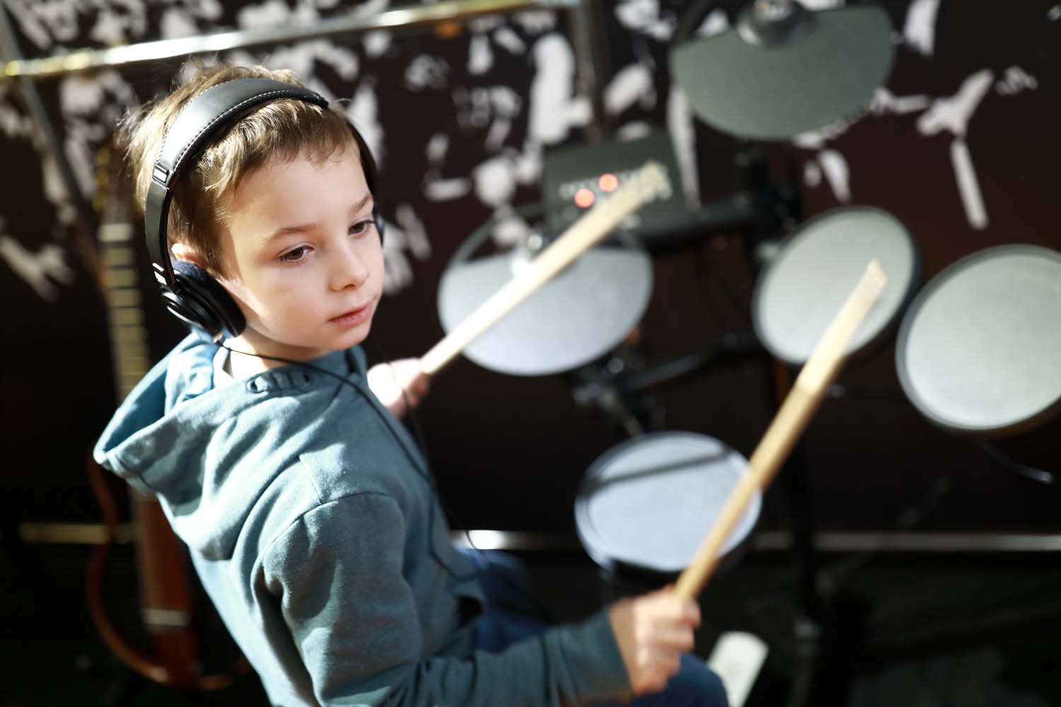 Autism & Positive Psychology image of a young boy playing drums