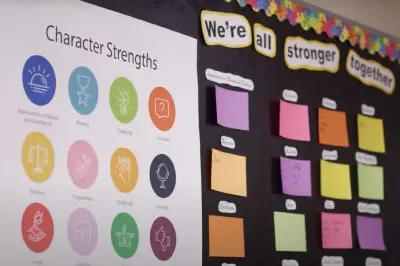 2.23.23_CSBulletinBoard Poster of the 24 Character Strengths on a bulletin board in a school hallway.