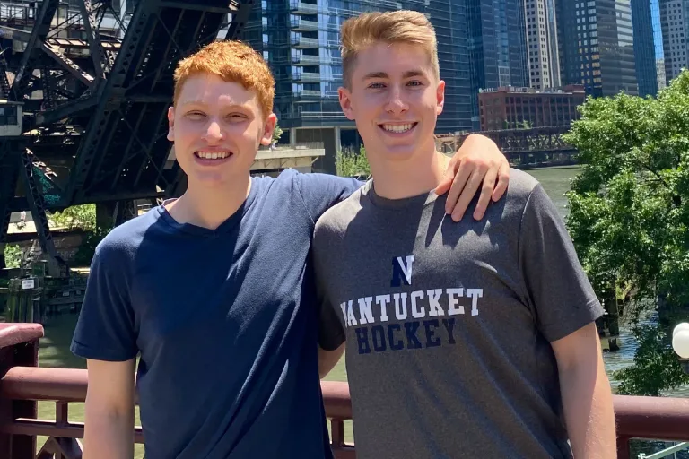 Dylan & Nick – Chicago River Dylan and Nick standing together smiling along the riverwalk in Chicago, IL.