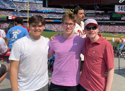 7.28.23_PhilliesGame Simon standing next to his two friends - Nick and Sebastian - at a Phillies baseball game.