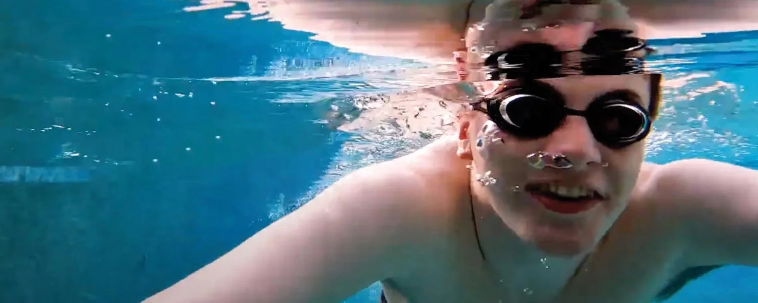 young man swimming with goggles