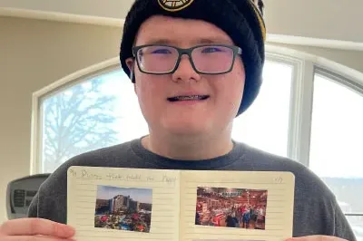 400x293_EPIC_ImpactStory_1 Christian holds up his positivity journal