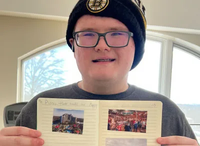 400x293_EPIC_ImpactStory_1 Christian holds up his positivity journal
