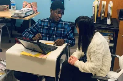 Drexel_5 Students discuss at desk with laptop