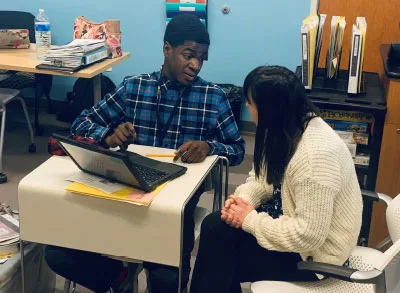 Drexel_5 Students discuss at desk with laptop