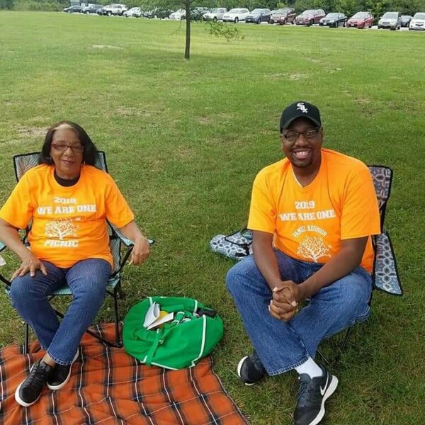 IMG_20210509_063312_444 Maurice and his mother are sitting on camping chairs in yellow shirts smiling