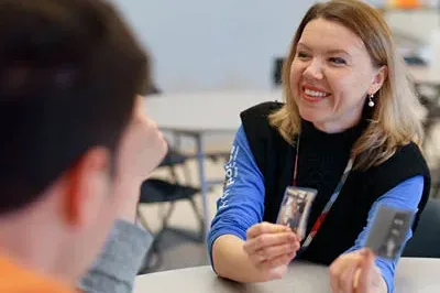 400x293_BacktoSchool_2024 A teacher shows her teenage student a flashcard