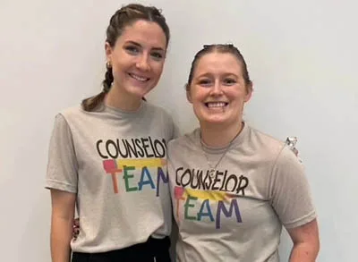 400x293_Layla autistic counselor Layla and her co counselor smile. Their t-shirts say "Counselor Team"