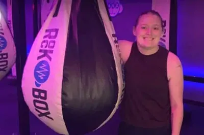 400x293_Layla_MforH Layla smiles next to her punching bag at a kickboxing class.