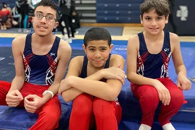 400x293_MforH_Shannon4 (1) three boys in gymnastics uniforms smile for the camera