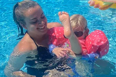 400x293_Lily_M4H (1) Lily is smiling in a swimming pool playing with her niece