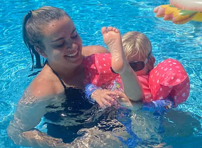 400x293_Lily_M4H (1) Lily is smiling in a swimming pool playing with her niece