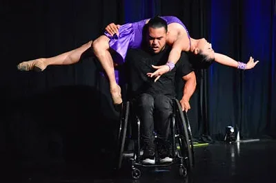 400x294_MarisaMfHappy8 (1) Marisa is wearing a purple dance dress and dancing with a man in black in a wheelchair.