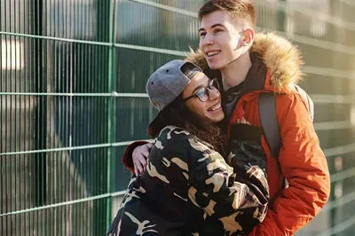 400x293_PWLoveBlog Teenage boy and girl outside smiling and hugging.