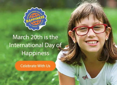 A young girl with brown hair and red glasses smiling with grass in the background and text over the grass that says, 