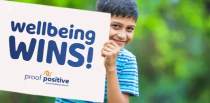 boy holding a "wellbeing wins" sign