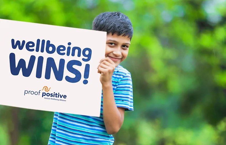 boy holding a wellbeing wins sign