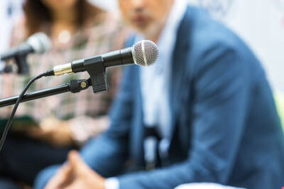 400x293_RoundtableBlog A picture of a microphone with people in the background.