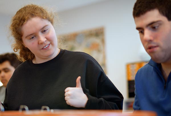 a young woman encouraging a young man with a thumbs up