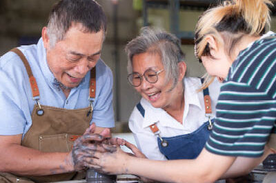 400x293_NDEAMBlog_Pottery Three people are engaged around a clay pottery wheel