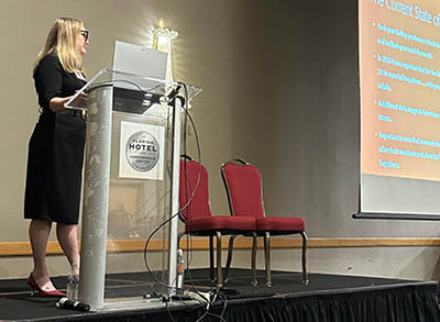 400x293_2026ConferenceCircuit Paige Raetz is at the podium presenting at a professional conference.